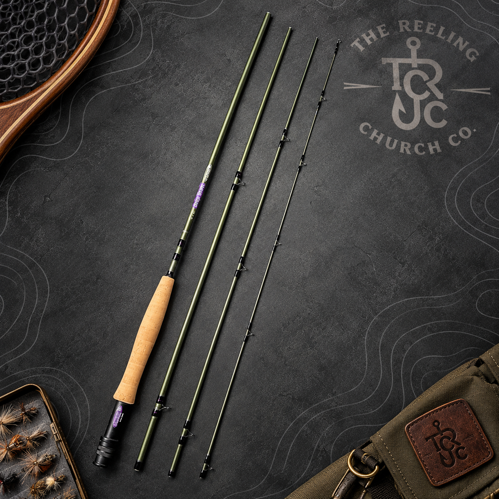 A fly fishing rod shown disassembled into four sections, laid out on a dark textured background next to a wooden fly box and a green bag. The rod has a light tan cork handle, black shaft sections, and purple accents near the reel seat.