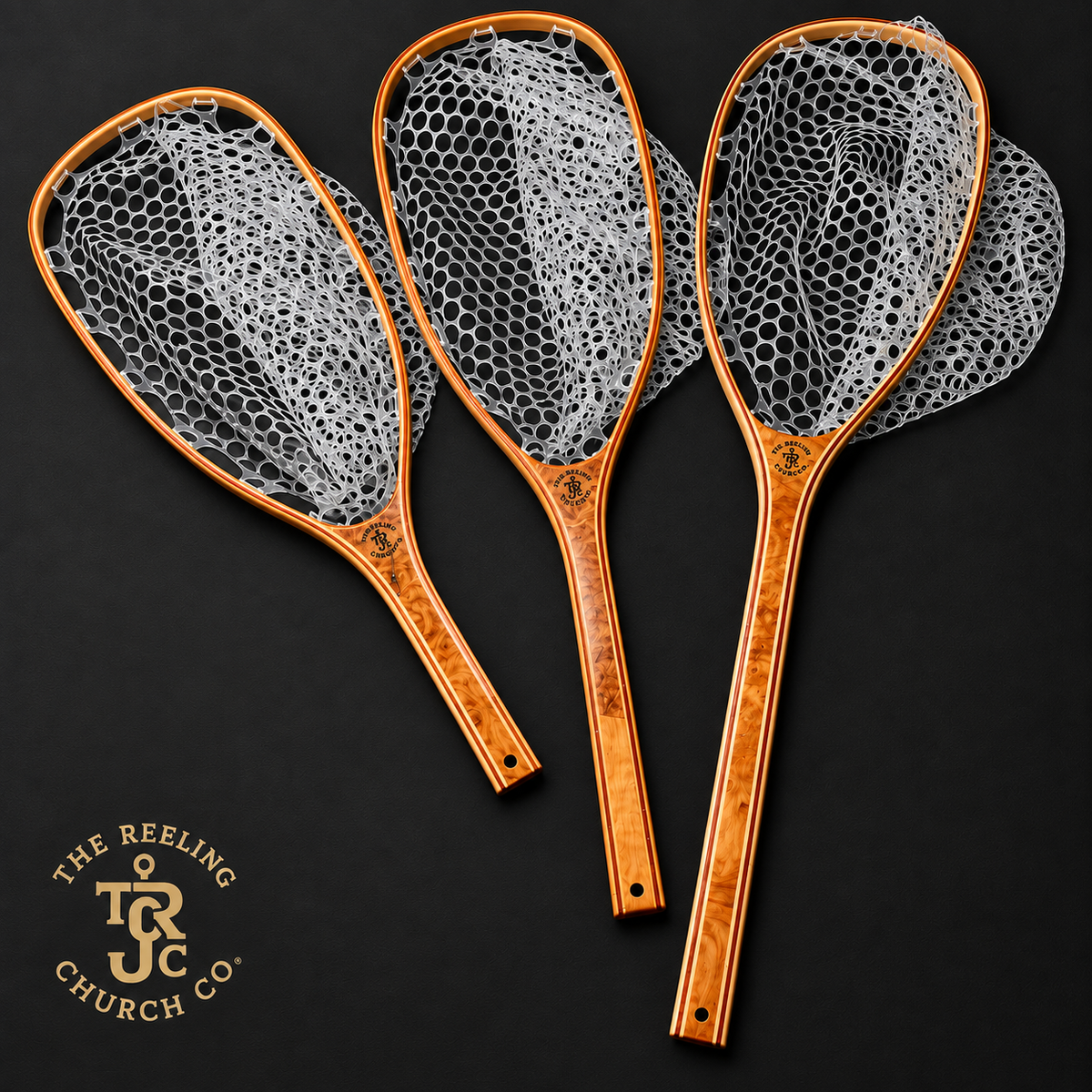 Three fly-fishing nets with copper-toned wooden handles and white mesh, arranged on a dark background. A logo for The Reeling Church Co.