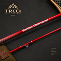 A close-up product shot of a red fishing rod section with white text reading 'Berkley Cherrywood' and a visible TRCC logo in the upper left. The rod is laid diagonally on a dark textured background with topographic contour lines, plus a small brown leather strap and part of a wooden accessory at the top right.